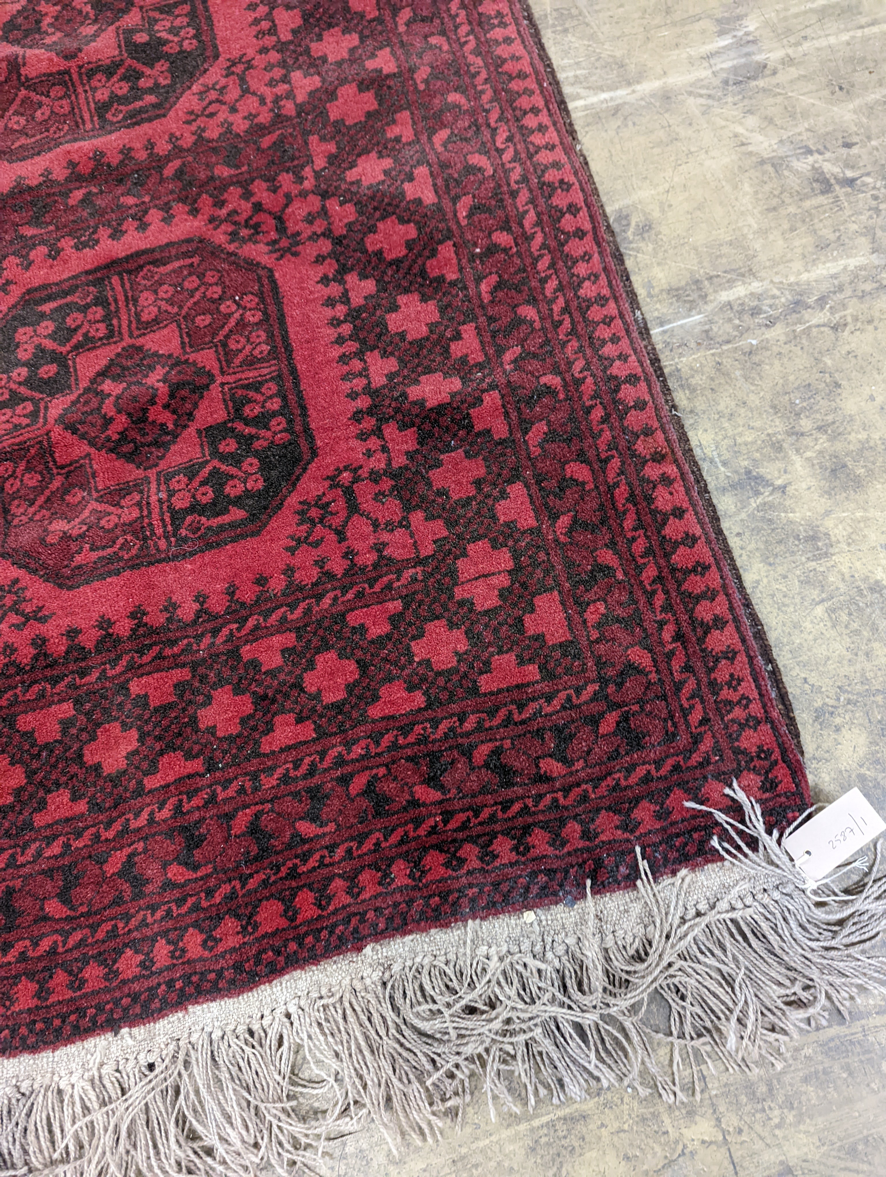 An Afghan red ground rug, 140 x 96cm